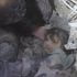 Momento in cui una bambina viene estratta dalle macerie di un edificio in Siria