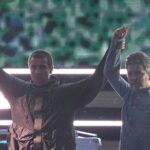 I fratelli Gallagher si danno il cinque e si abbracciano quando gli Oasis si riuniscono sul palco dopo 16 anni